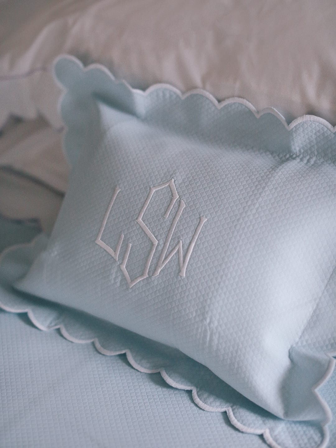 Dreamy Bedding with Matouk - A light blue, monogrammed pillow with scalloped edges